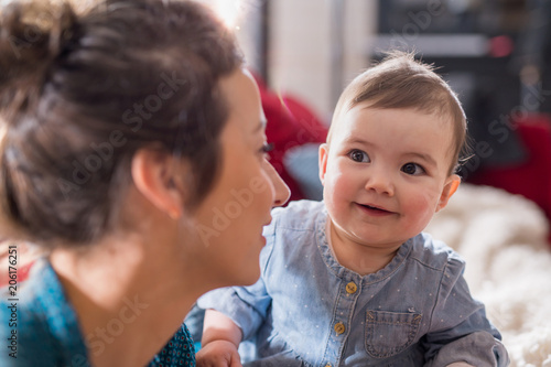Mommy plays with her cheerful baby at home