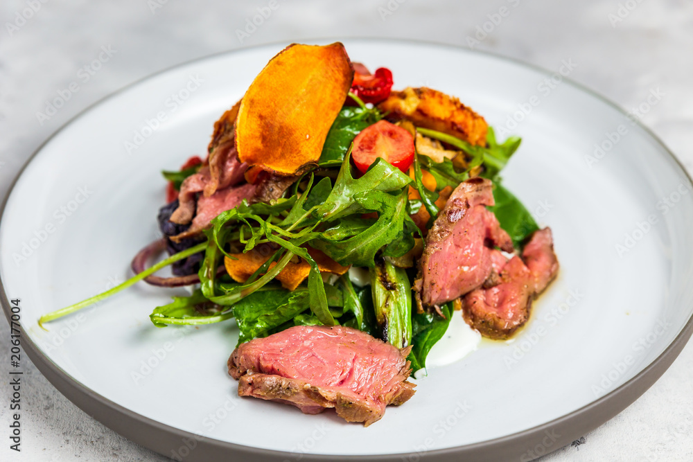 A warm salad with roastbeef, arugula, cherry tomatoes, dried carrot and grilled cheese. A warm salad with roastbeef, arugula, cherry tomatoes, dried carrot and grilled cheese.