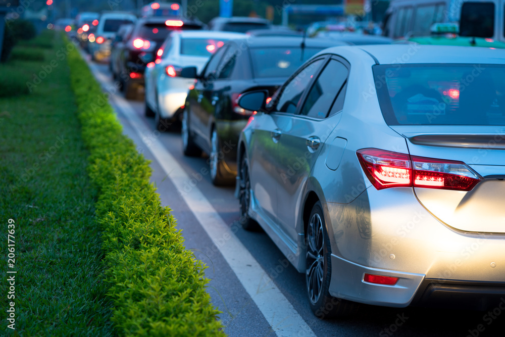 Cars on urban street in traffic jam at twilight