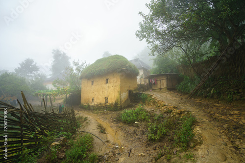 Ethnic minority Ha Nhi adobe-style thick-walled houses with mist in Y Ty, Lao Cai province, Vietnam photo