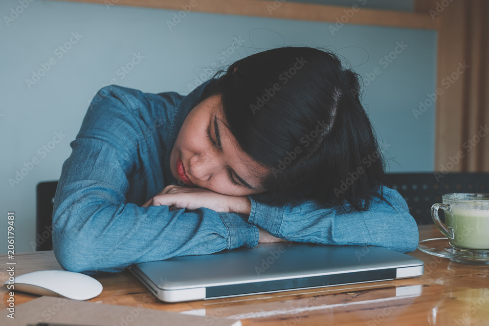 Business woman sleeping on the workplace. tired woman asleep on office desk.
