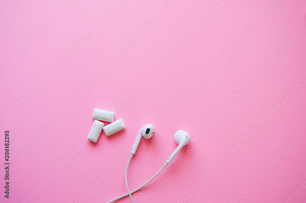 Headphones and menthol bubble gums on a pink background. Relaxation, life style concept. Copy space and top view.