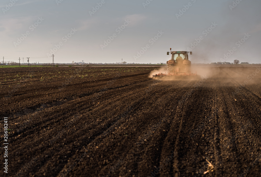 Fototapeta premium Tractor plowing fields -preparing land for sowing in autumn