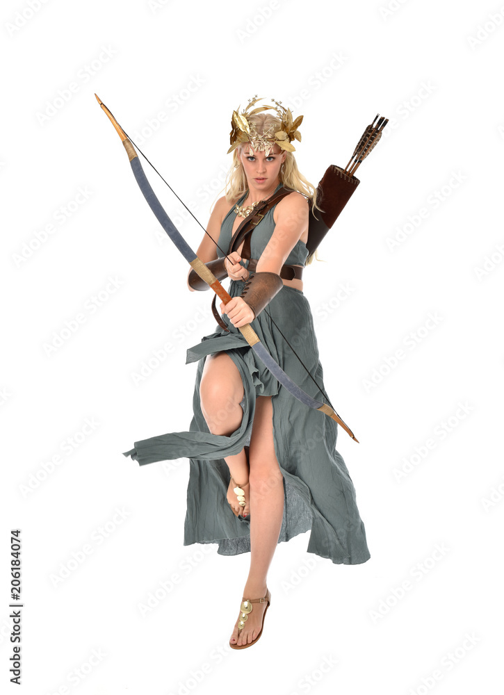 full length portrait of pretty blonde lady wearing fantasy toga gown, and holding a bow and arrow. standing pose on white background. full length portrait of pretty blonde lady wearing fantasy toga gown, and holding a bow and arrow. standing pose on white background.