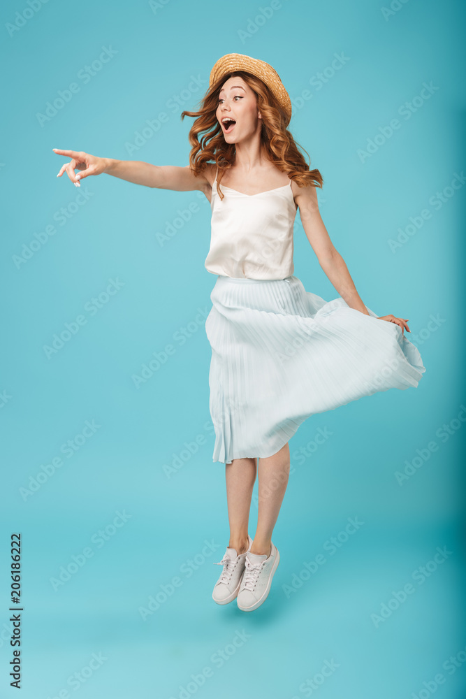 Young emotional caucasian woman jumping pointing aside. Young emotional caucasian woman jumping pointing aside.