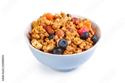 Bowl of homemade granola with fruit pieces isolated on white