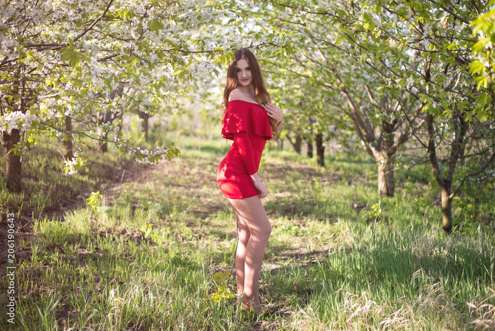 Beautiful young woman enjoying first rays of sun in a flowering spring garden Beautiful young woman enjoying first rays of sun in a flowering spring garden