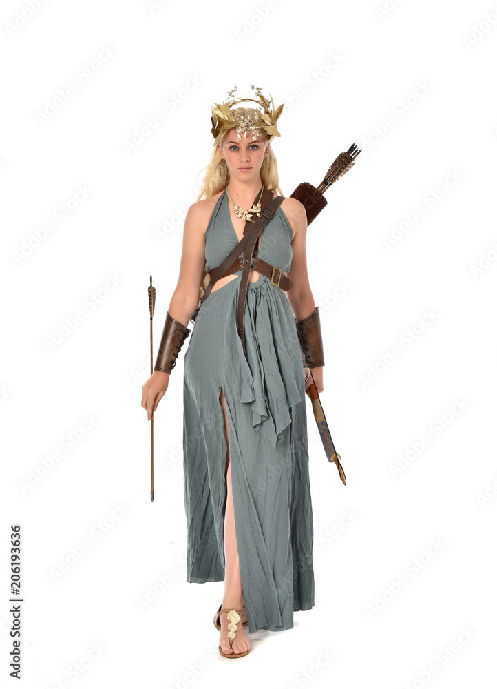 full length portrait of pretty blonde lady wearing fantasy toga gown, and holding a bow and arrow. standing pose on white background. full length portrait of pretty blonde lady wearing fantasy toga gown, and holding a bow and arrow. standing pose on white background.