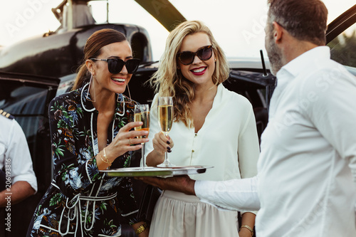 Man greets female friends with wine photo