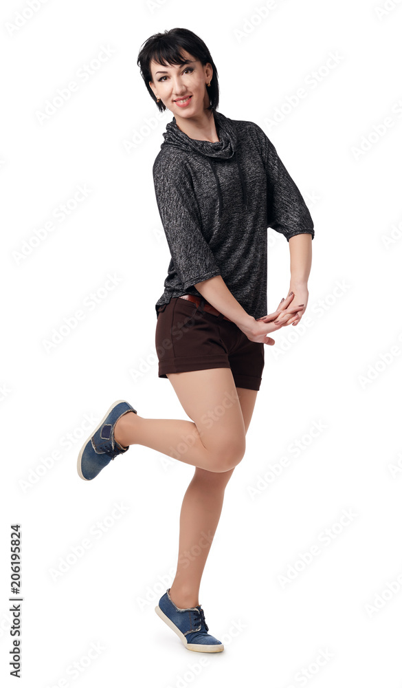 Fototapeta premium young woman posing in studio on white background, wearing brown shorts and shirt
