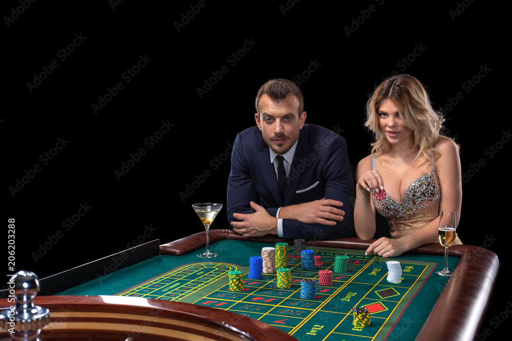 Couple gambling at roulette table in casino Couple gambling at roulette table in casino