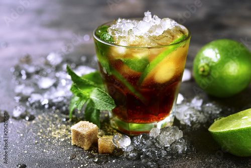 Cold refreshiing summer cocktail cuba libre or iced tea with lime.