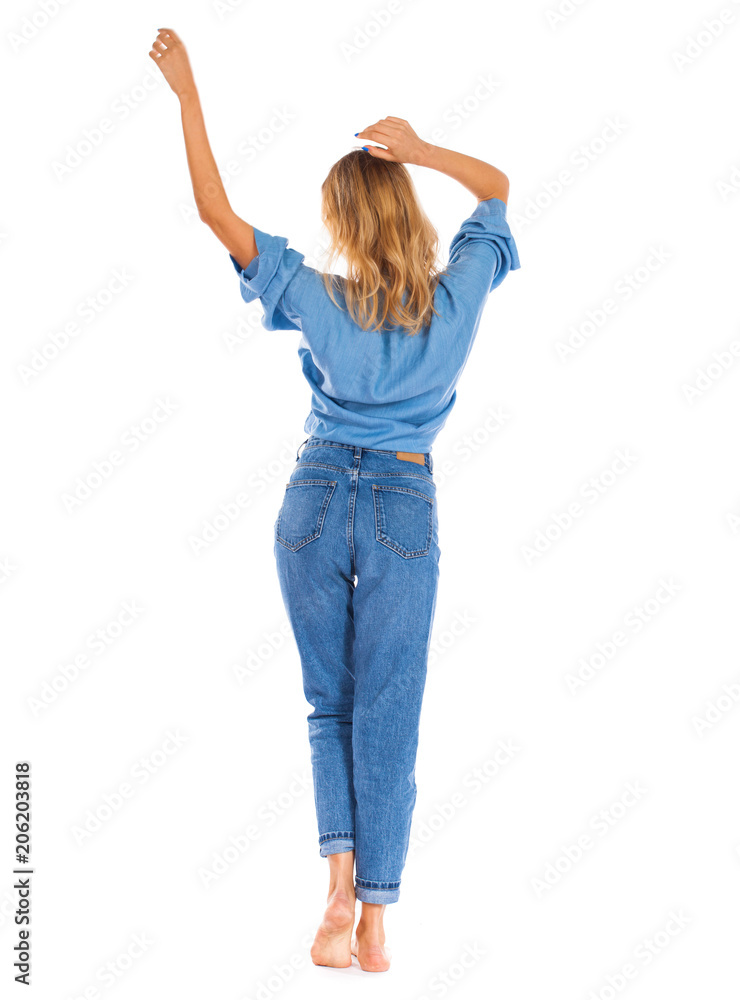 Young woman in blue jeans standing isolated on a white background Young woman in blue jeans standing isolated on a white background