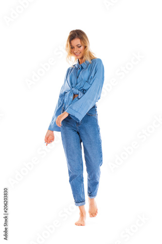 Young woman in blue jeans standing isolated on a white background