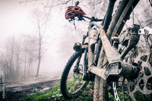 Fototapeta Naklejka Na Ścianę i Meble -  Mountain bike and helmet in autumn woods, dirty bicycle