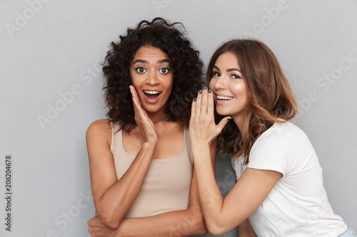 Konstfotografi Portrait of two happy young women sharing secrets