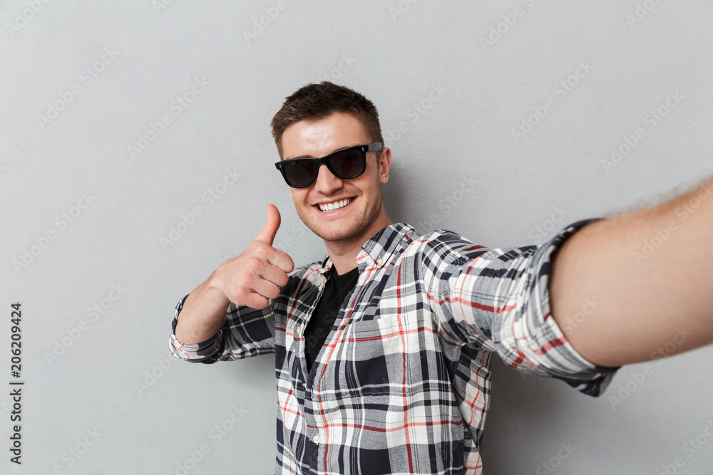 Fototapeta premium Portrait of a smiling young man in plaid shirt