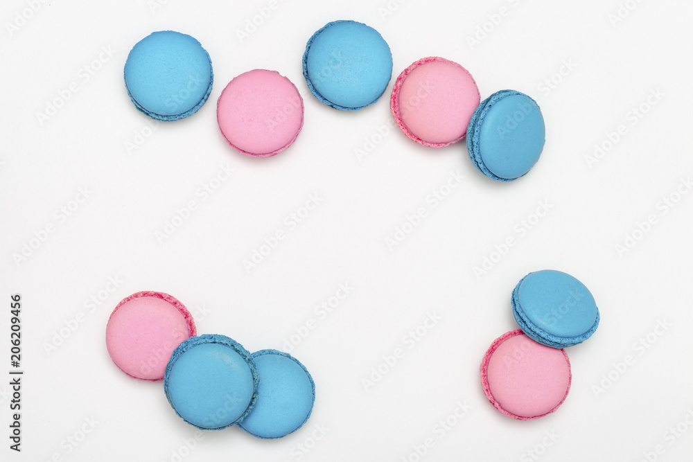 Heap of sweet macaroons of blue and pink color close-up on a white background. Cookies with lavender aroma. Copy space. Selective focus.