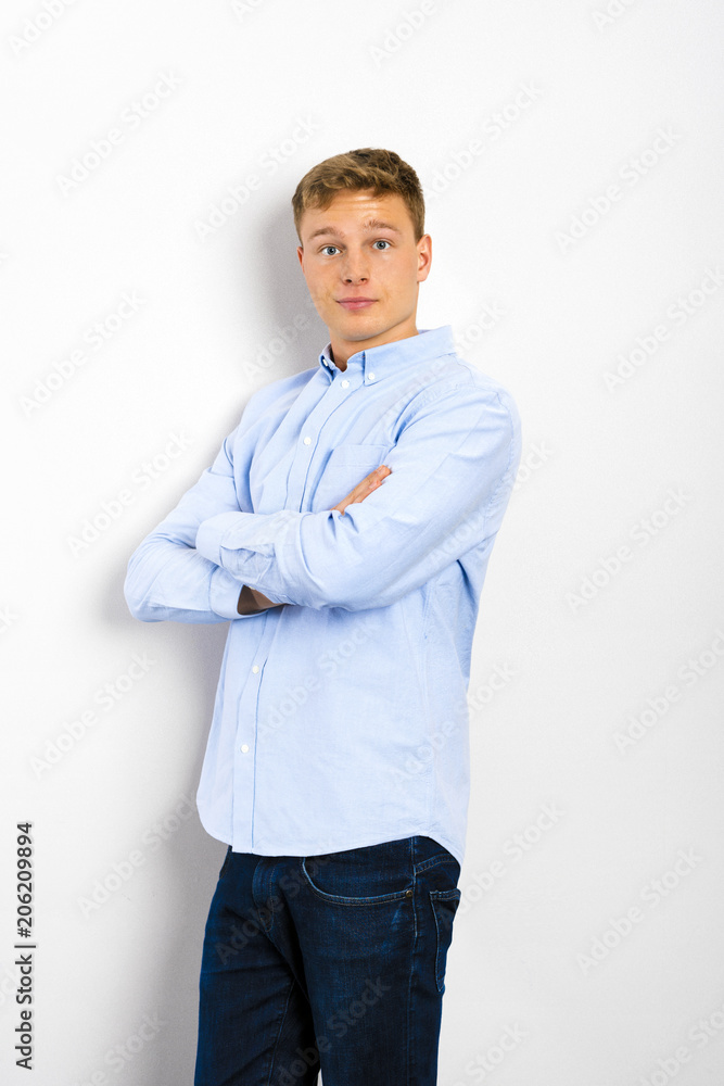 Young man looking up and standing against white wall. Young man looking up and standing against white wall.