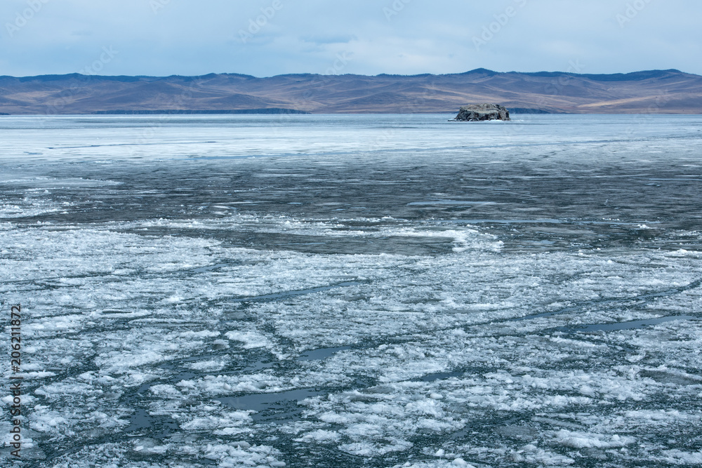 The white ice floes on the blue water of the lake. Lake Baikal in spring.