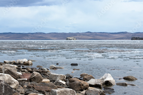 The white ice floes on the blue water of the lake. Lake Baikal in spring.