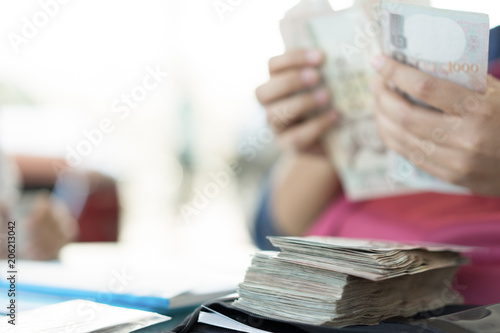Asian woman girl hand counting cash money for pay loan.