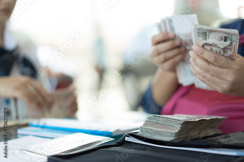 Asian woman girl hand counting cash money for pay loan.