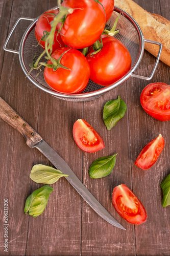 Frische Tomaten liegen in einer Schale auf einem Holztablett