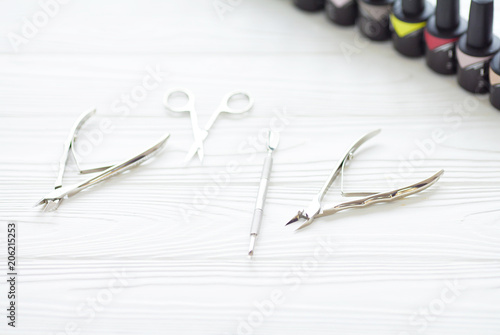 Top view of manicure and pedicure equipment on white wooden background