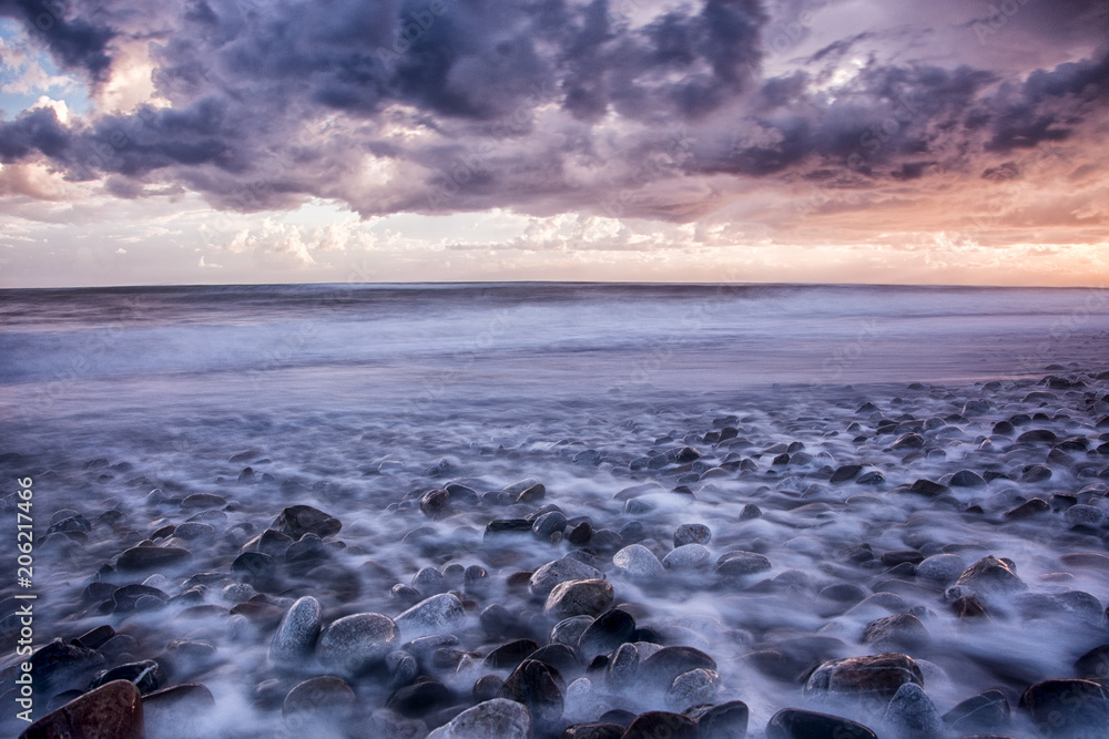 Fototapeta premium blue, purple sunset dramatic, colorful Sunset at the beach with rocks