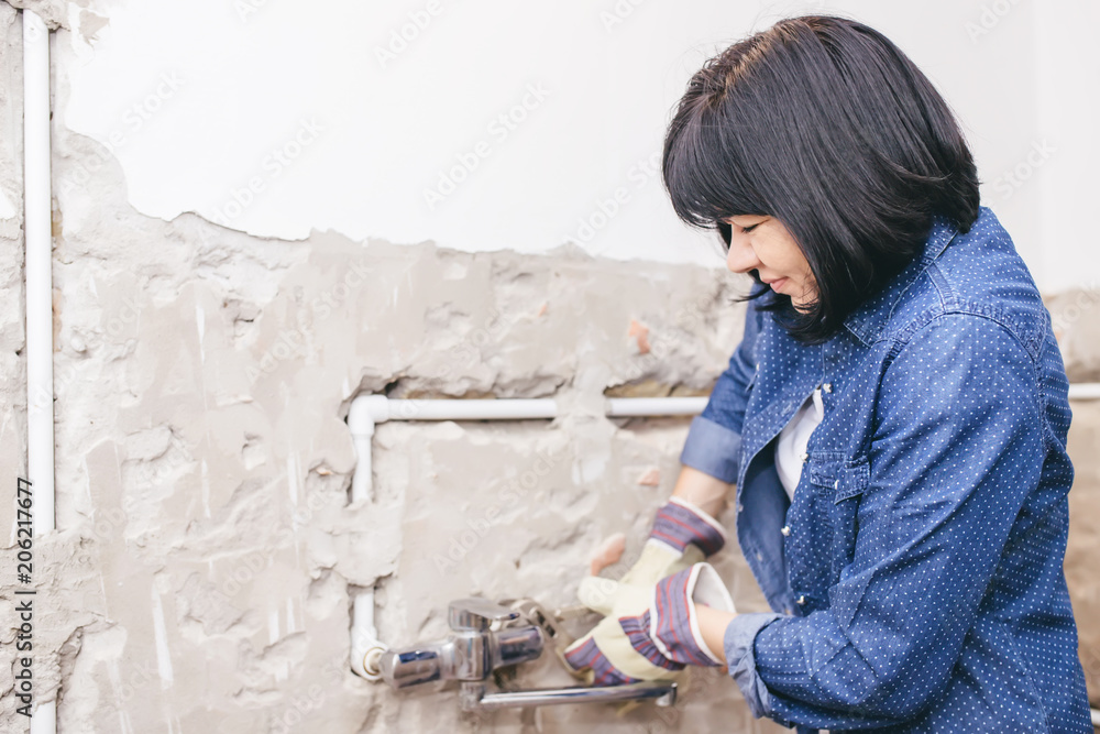 Woman repairing her bathroom sink pipe Woman repairing her bathroom sink pipe