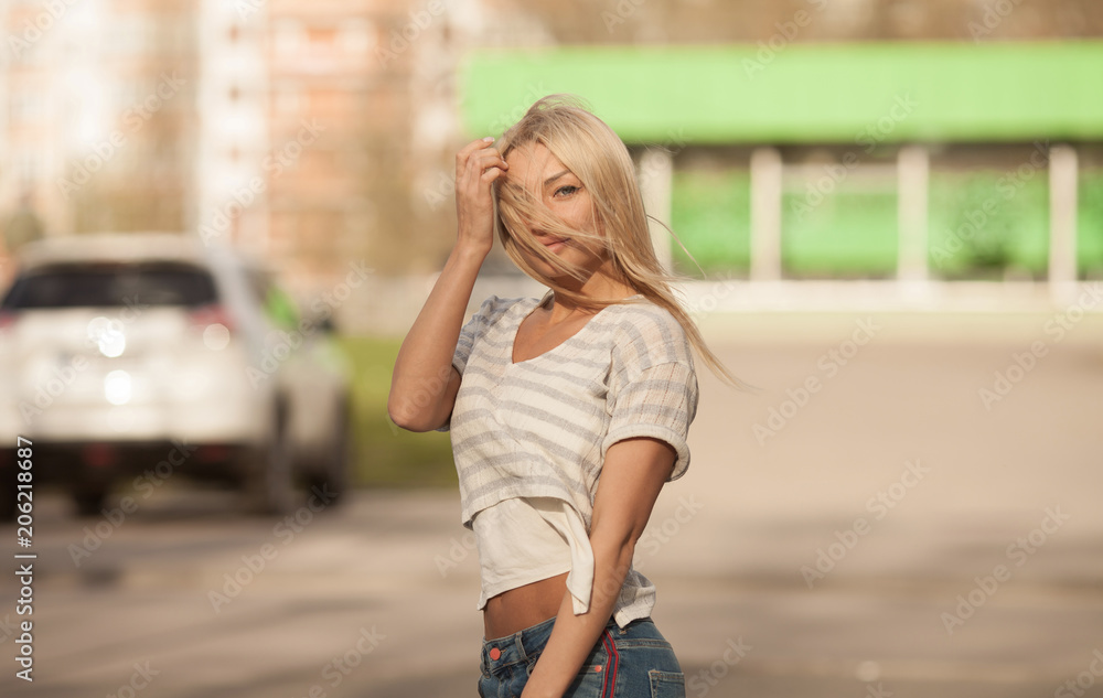 Portrait of the young beautiful smiling woman outdoors enjoying summer sun. Young woman outdoors portrait. Soft sunny colors. Beautiful blonde woman outdoor