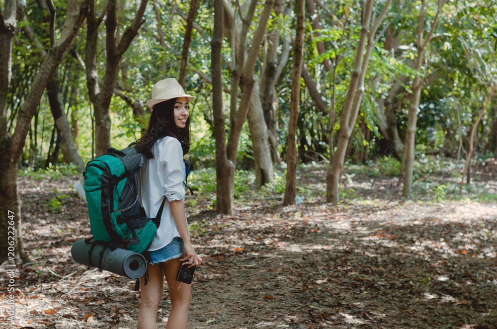 attractive woman take classic camera with backpack adventure hiker walking go to trekking in the forest sightseeing natural at holiday travel concept. photographer using camera take a photo.