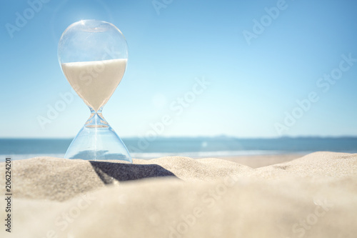 Canvas Print Hourglass time on a beach in the sand