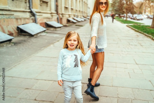 Mother and her little daughter walking on the street © bedya