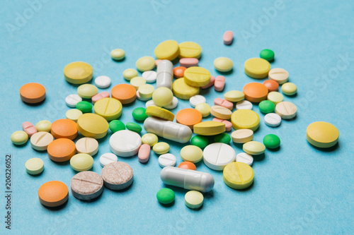 on the blue surface scattered multi-colored tablets, the concept of medicine and allergy