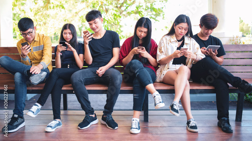 Group adult hipsters friends sitting sofa using hands modern smartphone tablet  Business startup friendship teamwork concept  People working together project
