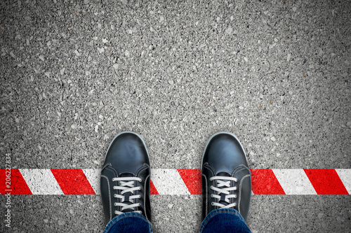 Black shoes standing on the red-white line