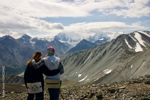 two girl friends look at the mountains