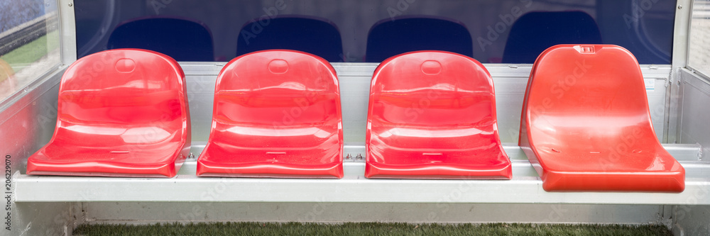Obraz premium Detail of red Reserve chair and staff coach bench in sport stadium