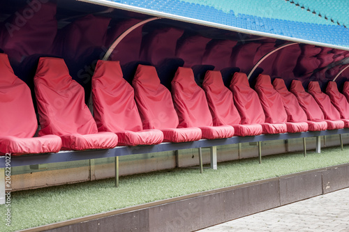 Detail of red Reserve chair and staff coach bench in sport stadium photo