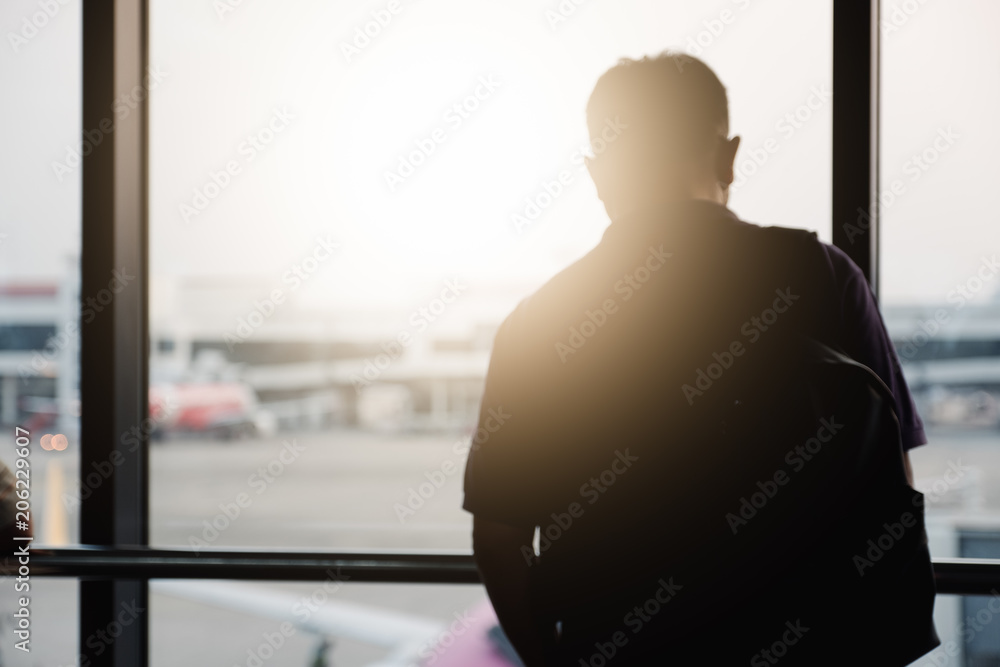 Blurred man in the airport, looking through the window at planes Blurred man in the airport, looking through the window at planes