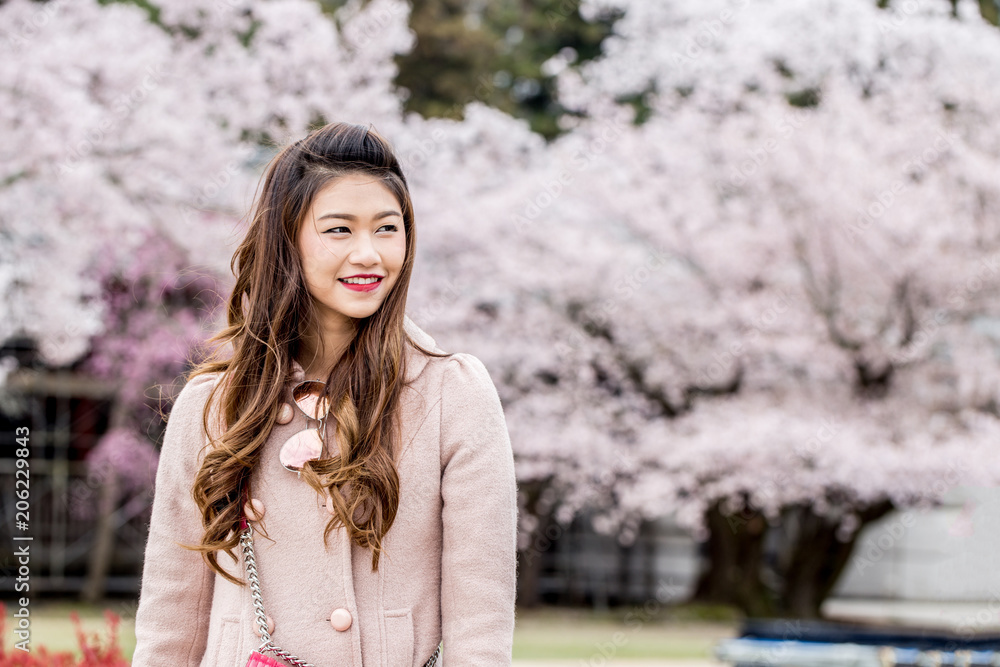 Portrait Beautiful Attractive Asian woman smile with cherry blossom or sakura flower feeling so happiness and cheerful Portrait Beautiful Attractive Asian woman smile with cherry blossom or sakura flower feeling so happiness and cheerful