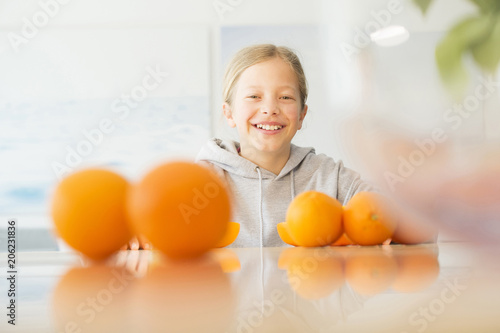 Portrait of happy girl with oranges in kitchen photo