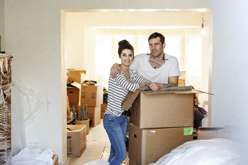 Young couple moving house, unpacking cardboard boxes Young couple moving house, unpacking cardboard boxes