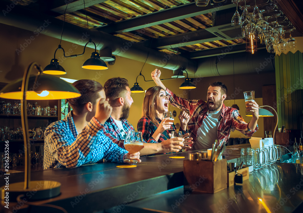 Sport, people, leisure, friendship and entertainment concept - happy football fans or male friends drinking beer and celebrating victory at bar or pub Sport, people, leisure, friendship and entertainment concept - happy football fans or male friends drinking beer and celebrating victory at bar or pub