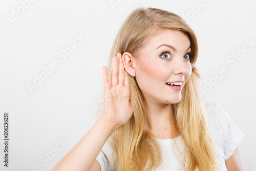 Woman putting hand ear to hear better