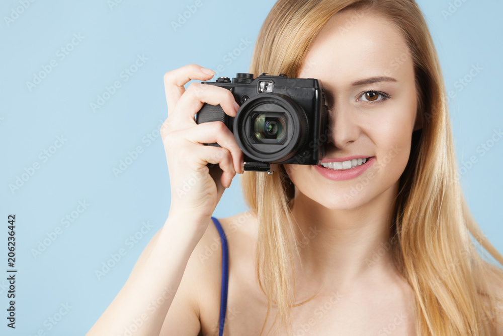 Blonde woman with camera on blue Blonde woman with camera on blue