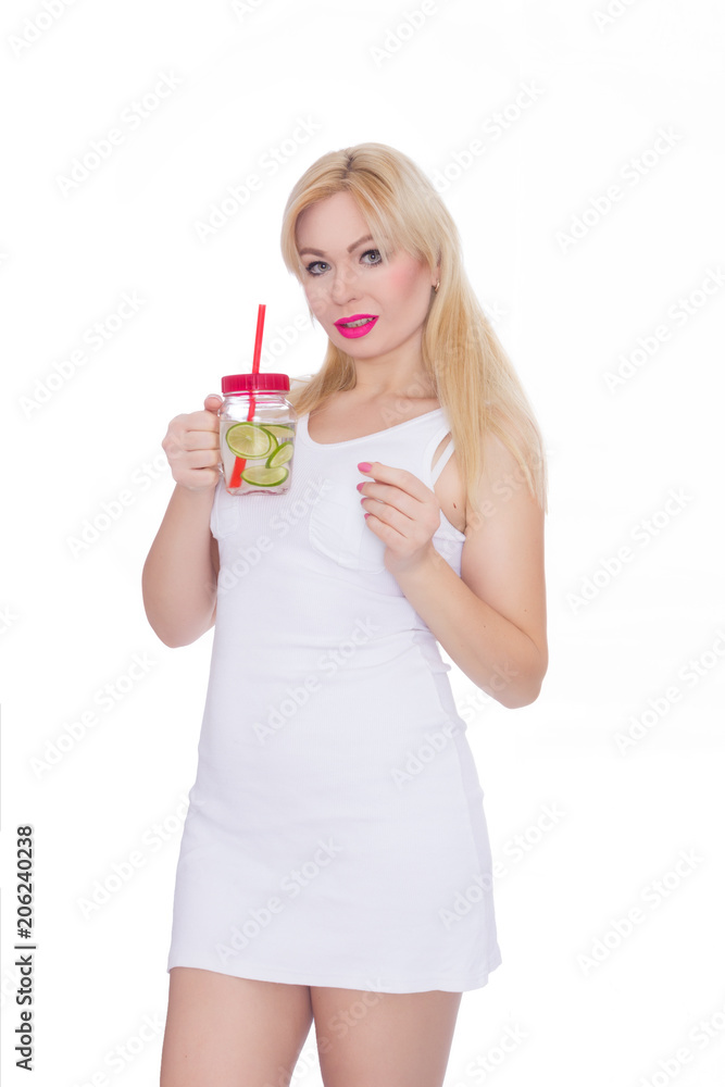 A friendly blond woman holds a glass of water and lime in her hands. A girl is drinking lemonade. Concept - healthy food, thirst quenching in summer A friendly blond woman holds a glass of water and lime in her hands. A girl is drinking lemonade. Concept - healthy food, thirst quenching in summer
