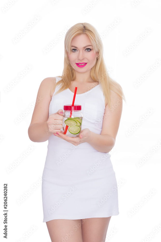 A friendly blond woman holds a glass of water and lime in her hands. A girl is drinking lemonade. Concept - healthy food, thirst quenching in summer A friendly blond woman holds a glass of water and lime in her hands. A girl is drinking lemonade. Concept - healthy food, thirst quenching in summer